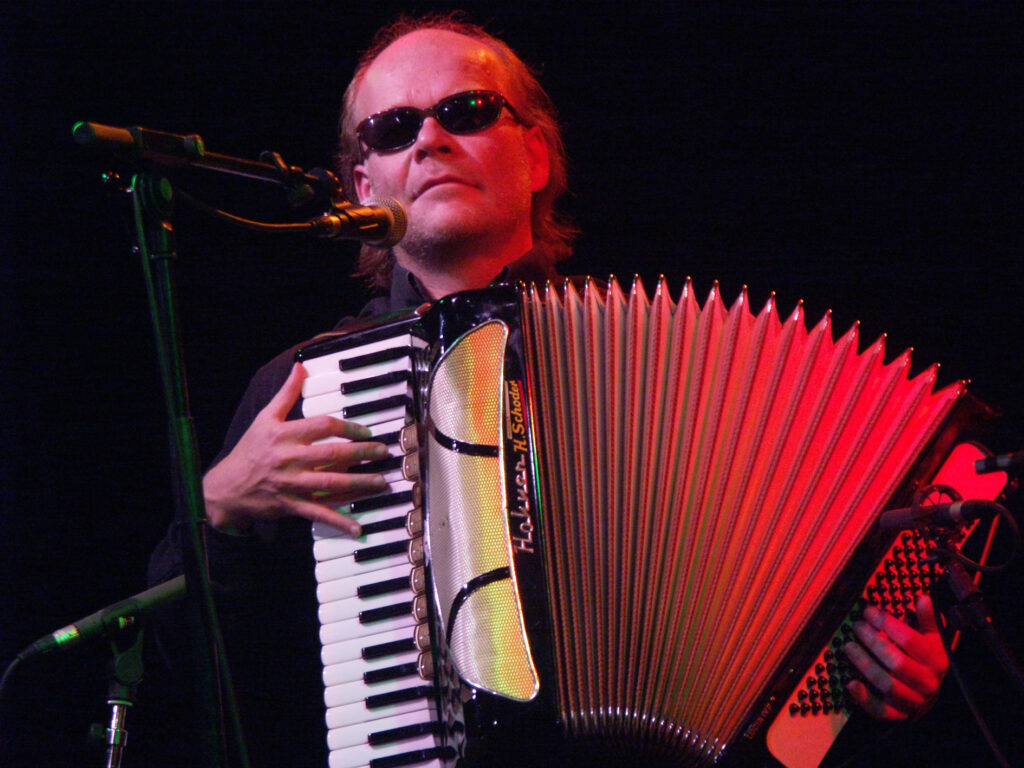 Otto Lechner - Dark Side of the Accordeon. Der Musiker Otto Lechner auf der Bühne mit dunkler Sonnenbrille und Accordeon.